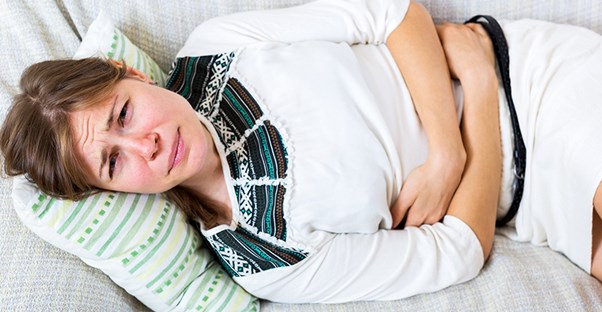Woman holding stomach in pain. Pancreatitis.