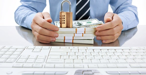 Man holding stack of cash and a lock. Becoming an Actuary.