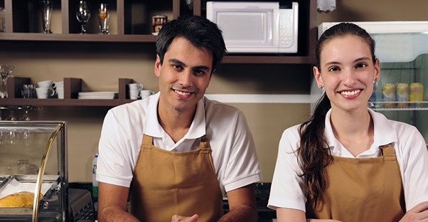 Smiling workers behind the counter of a small business.