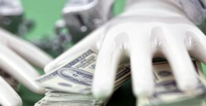 Hand grabbing a pile of cash. Pyramid vs ponzi scheme.