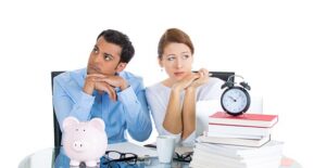 Man and woman at desk looking concerned.