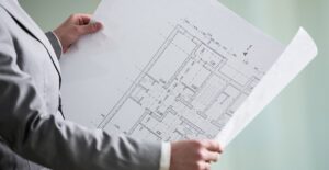 Home inspector looking at blueprint.
