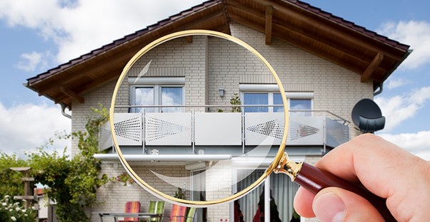 Looking at a house through a magnifying glass. Home inspections.
