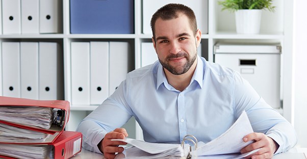 A man goes through paperwork to set up a payroll service.