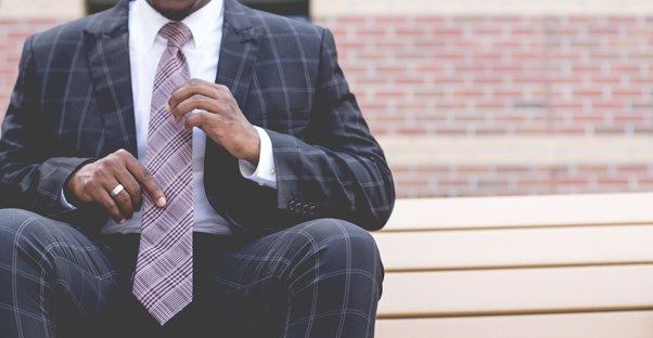 a small business owner adjusts his tie and ponders his retirement plan options