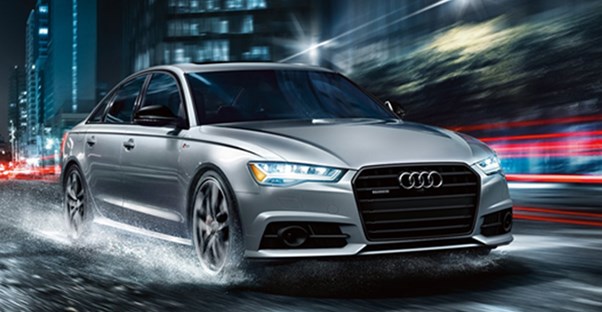 a silver audi a6 driving down the road
