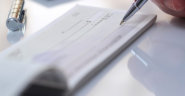 An individual is about to write a check to deposit into a checking account.