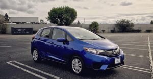 a blue 2017 honda fit in a parking lot
