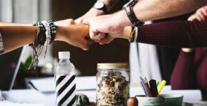 several coworkers perform a group fist bump