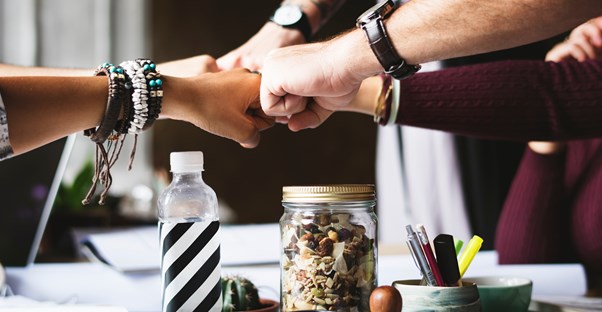 several coworkers perform a group fist bump