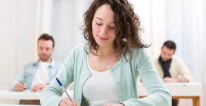 a woman and two men take practice lsat exams at a test prep center
