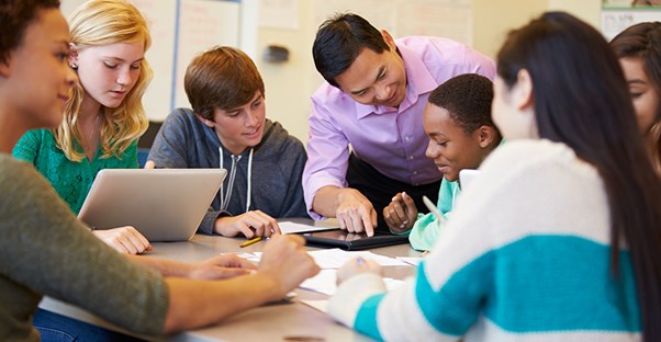 a teacher shows students how to use tablets