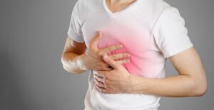 a man holds his chest that glows red symbolizing a pulmonary embolism