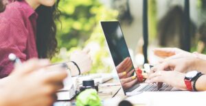 students complete online marketing degree programs on their laptops
