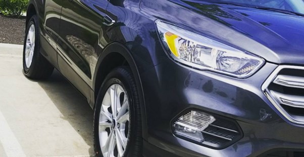 a blue ford escape in a driveway