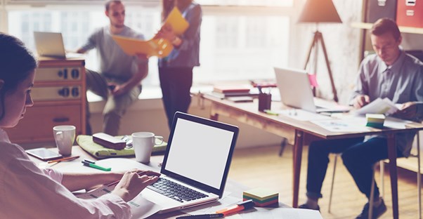 a marketing firm explores online digital marketing programs on their computers in their office