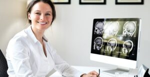 woman at desk. medical assistant certificate vs associates degree