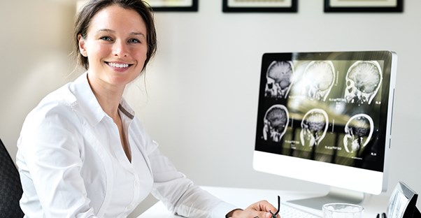 woman at desk. medical assistant certificate vs associates degree