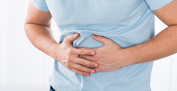 man holding stomach. stomach cancer