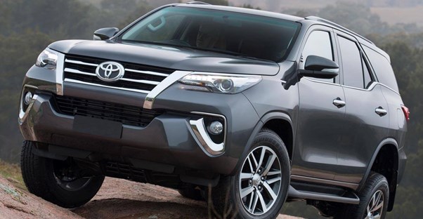 a dark gray 2018 toyota 4runner driving off road over rocks