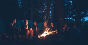 people cooking food around a campfire