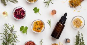a bottle of essential oils and flowers surrounding it to suggest scent