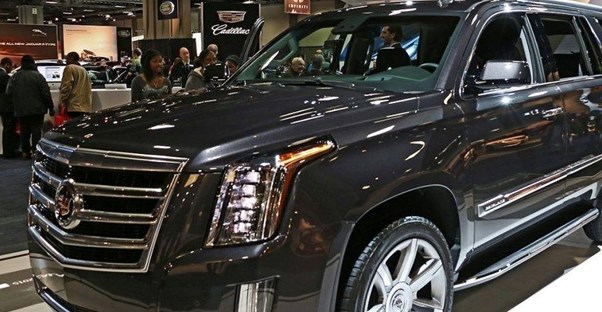 a dark gray 2019 cadillac escalade at an auto show