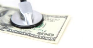 Stethoscope, presumably taking the heart beat of a hundred dollar bill