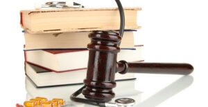 Gavel, stack of books, stethoscope, and pills.