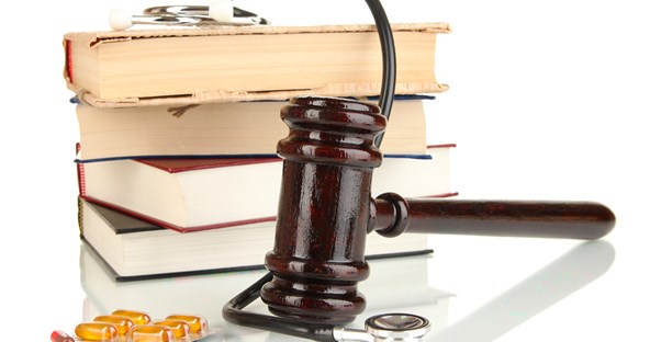 Gavel, stack of books, stethoscope, and pills.