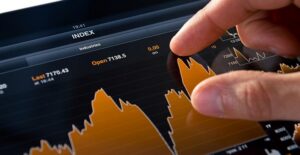 Person examining a stock market graph on a tablet