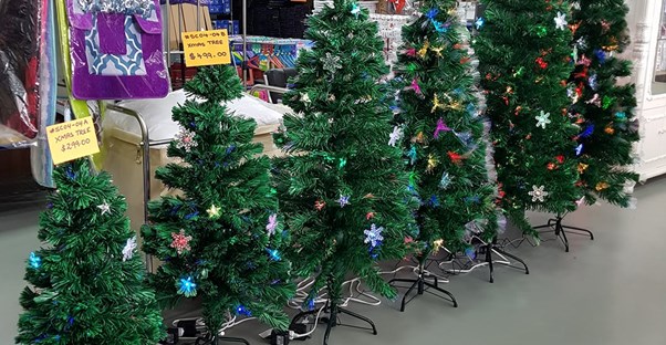 row or christmas trees in a store