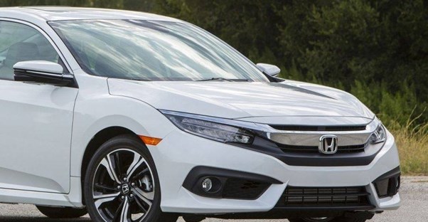 a white 2019 honda civic driving down the road