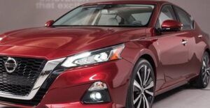 a red 2019 nissan altima on an auto show pedestal