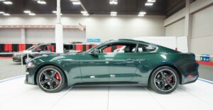 a green 2019 ford mustang bullitt in an auto showroom