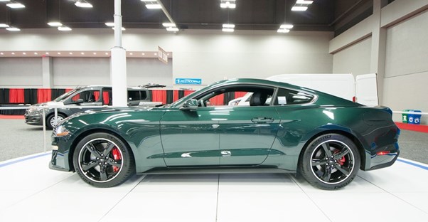 a green 2019 ford mustang bullitt in an auto showroom