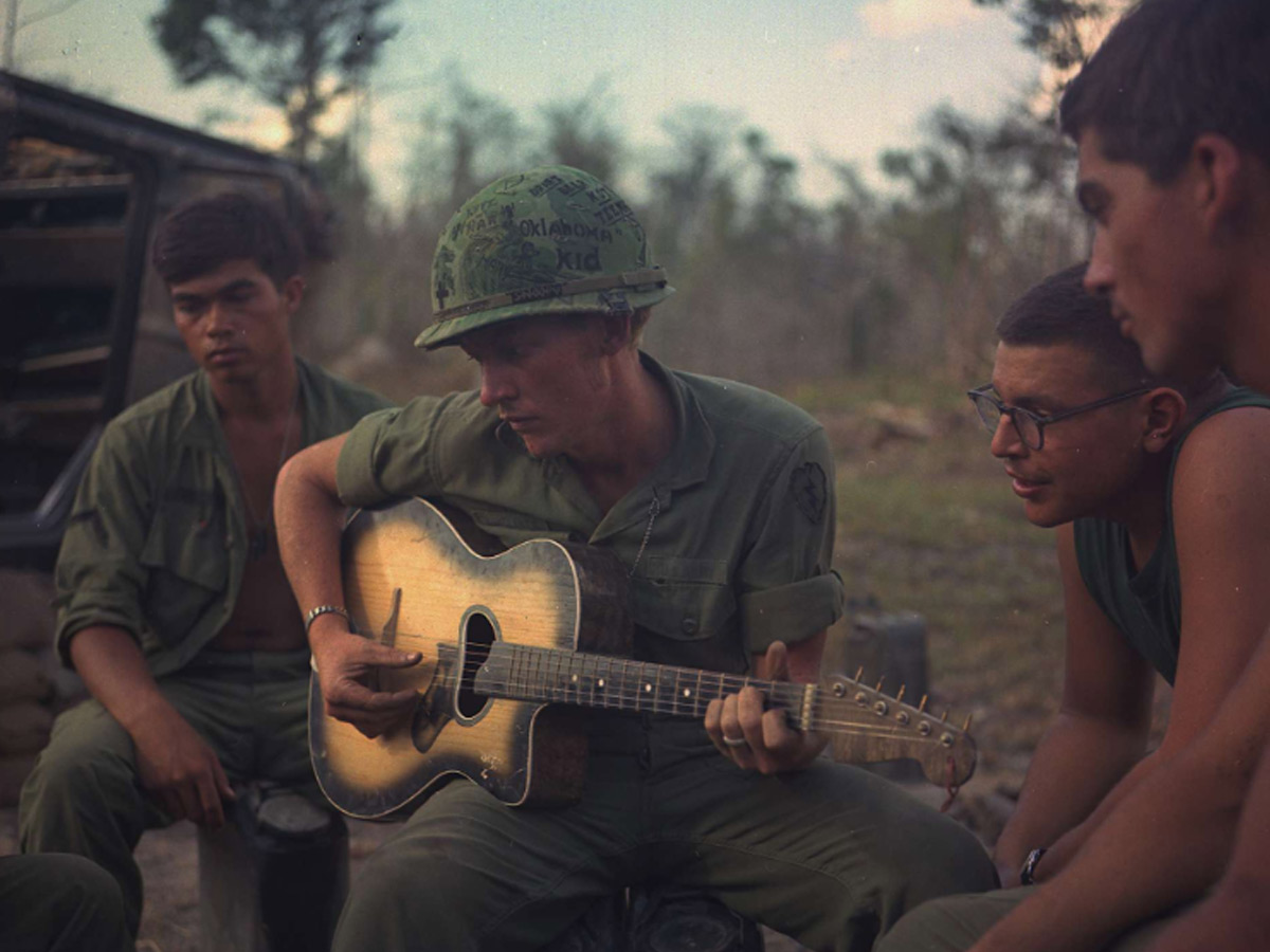 Company Gathers Around a Guitar