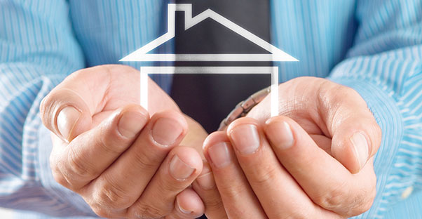 Man hands holding an outline of a house