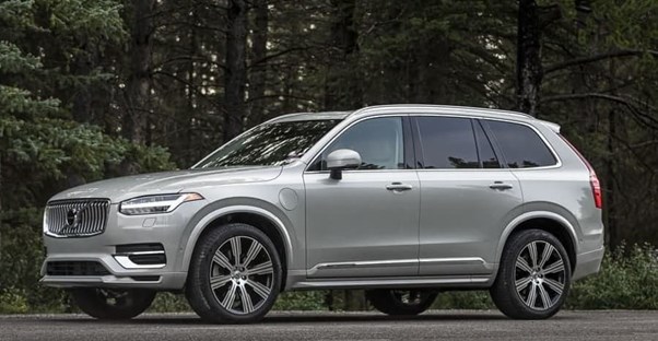 a 2020 volvo xc90 in a parking lot near the forest