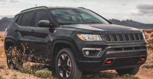 a black 2020 jeep compass trailhawk off roading on a trail
