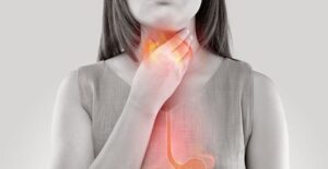 A woman in gray-scale with a red and orange overlay of her esophagus and stomach