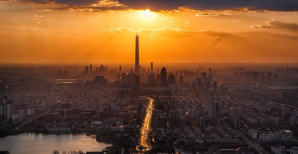 the tall buildings of a city in front sunset