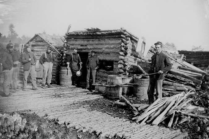 Soldiers Gather Around the Log Hut Company Kitchen