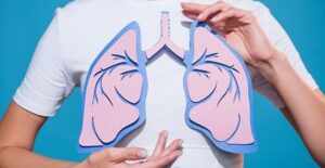 young man holding up a lung diagram