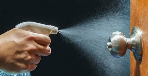 Image of disinfectant spray on doorknob