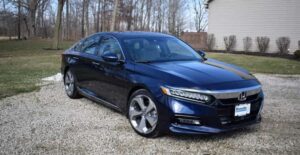 a black 2021 honda accord parked beside a house