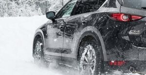 a black 2021 mazda cx5 driving in the snow