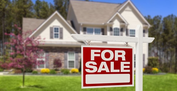 Large two story house with a for sale sign out front