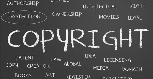 The word copyright written on a chalkboard surrounded by smaller related legal terms.