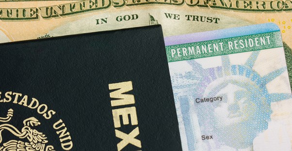a Mexican passport, U.S. permanent resident card, and dollar bill in a pile